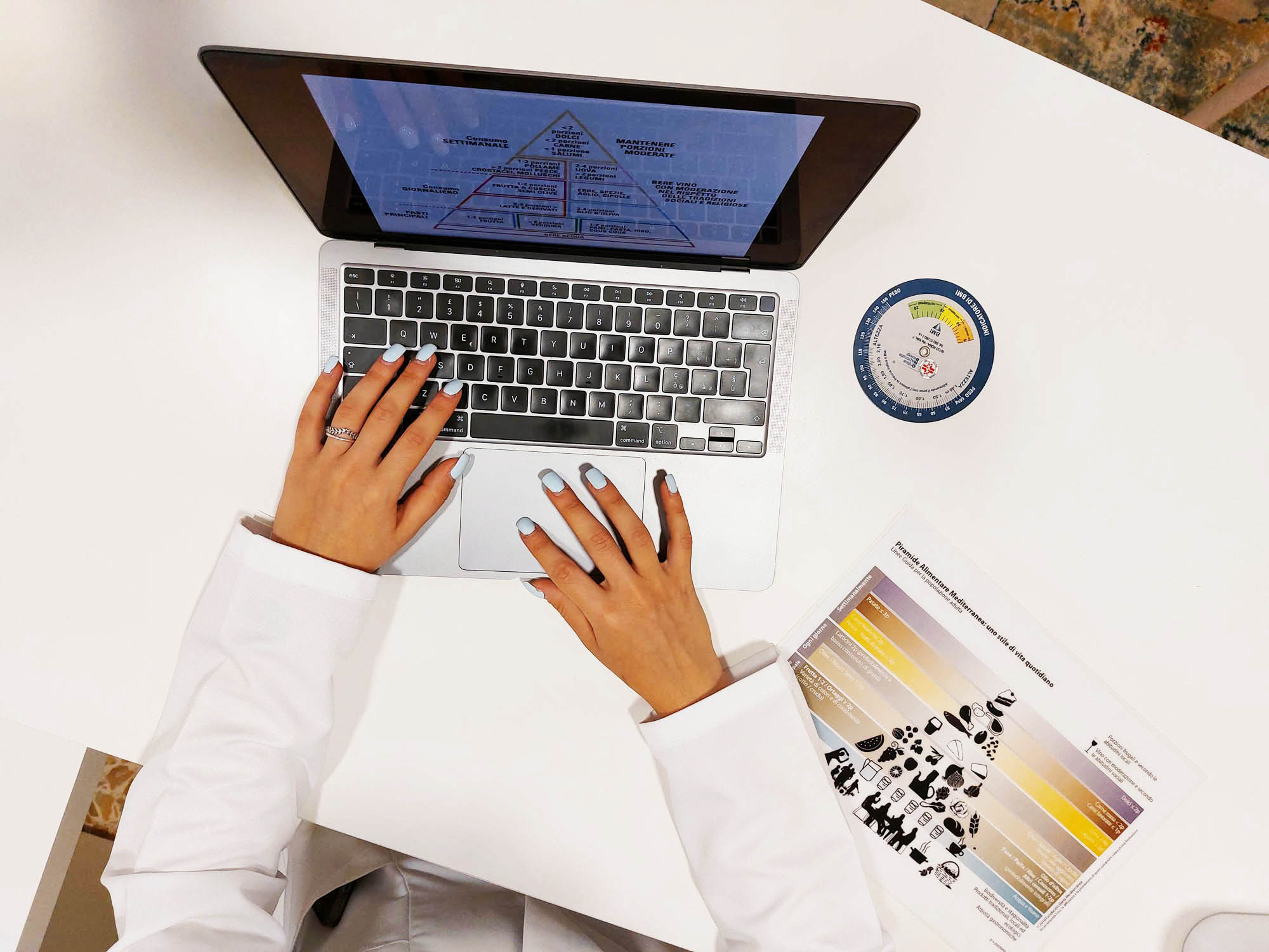 Consulenza nutrizionale online - Dott.ssa Alessandra Armili al lavoro con piramide alimentare mediterranea e strumenti professionali