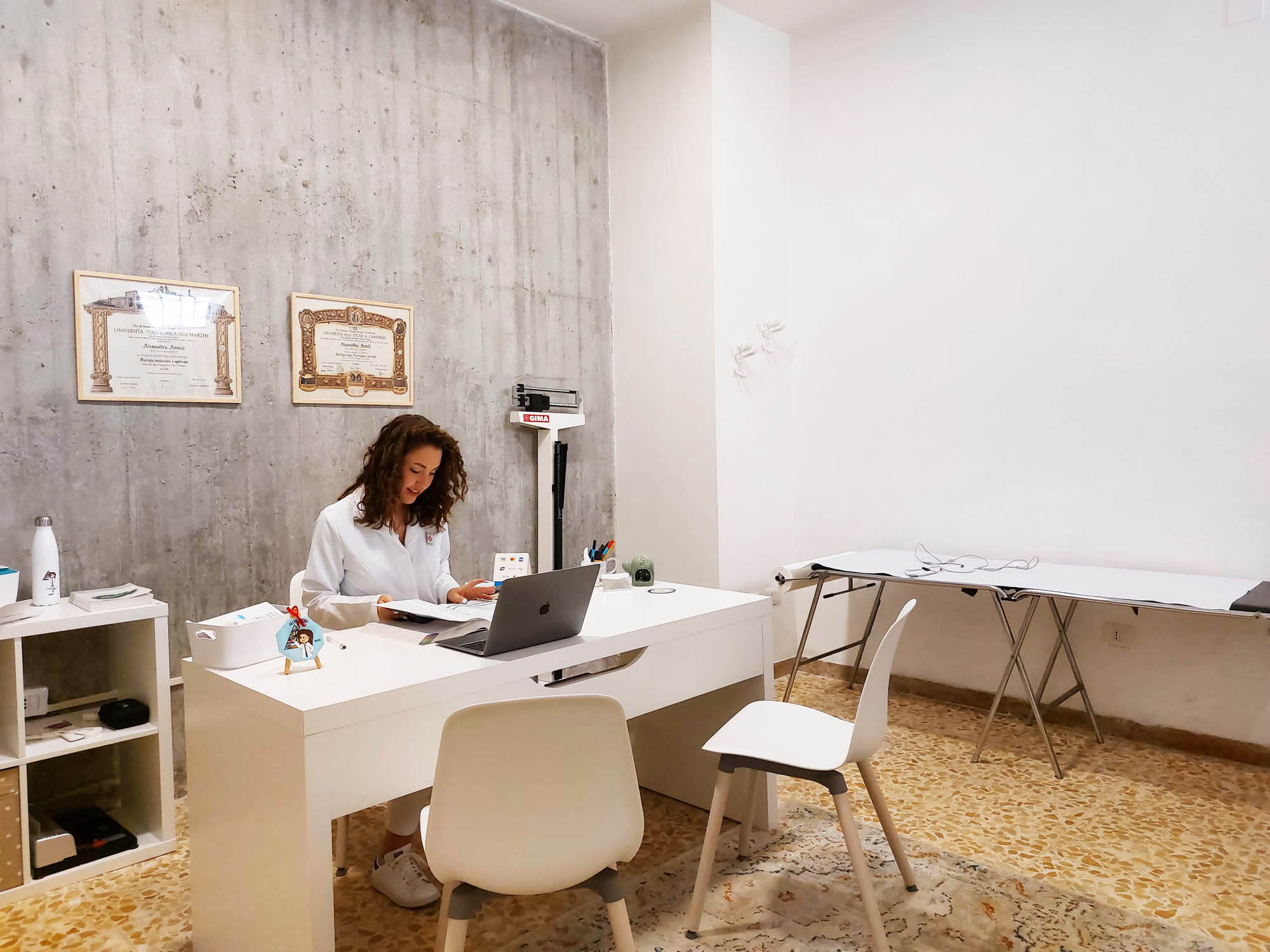 Studio nutrizionista Ascoli Piceno - Dott.ssa Alessandra Armili al lavoro nel suo studio professionale con bilancia GIMA e attrezzature per visite nutrizionali